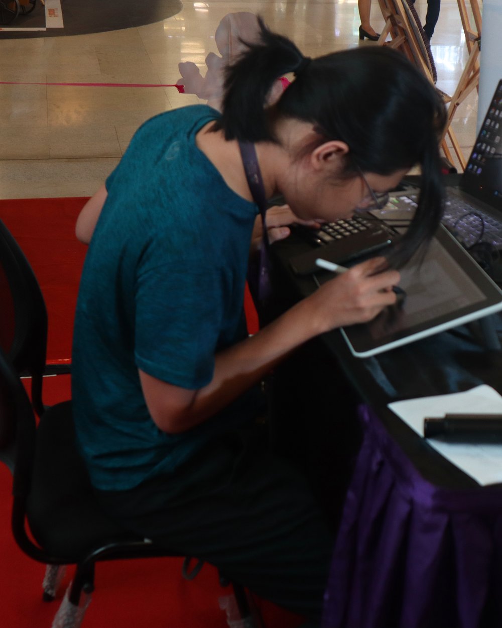 An MCTC student drawing on a graphics tablet at a showcase